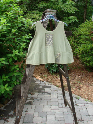 1995 Klee Top Single Beetle Time Marsh Size 1 displayed on a swinger, showcasing its swingy A-line crop shape, scooped neckline, and distinctive hand-stamped button, embodying Blue Fish's playful vintage style.