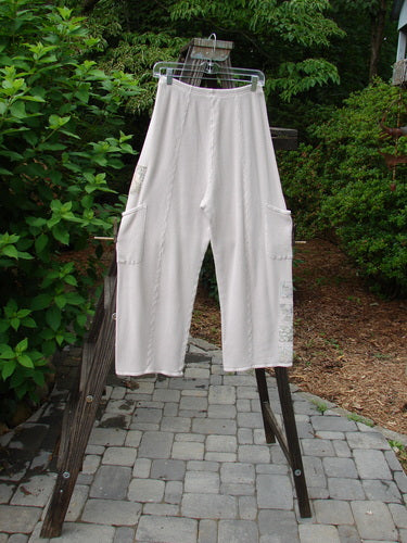 A pair of white pants with painted garden patches, full elastic waistline, and deeper drop exterior pockets. Size 1, Barclay Thermal Patched Pottery Pant Garden Pink Cloud.