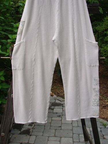 A pair of Barclay Thermal Patched Pottery Pants in Pink Cloud. Features include a full elastic waistline, vertical stitchery, generous hip measurements, slightly tapered lowers with flat tape accents, sweet painted garden patches, a slightly longer inseam, and super fun deeper drop exterior pockets. Size 1.