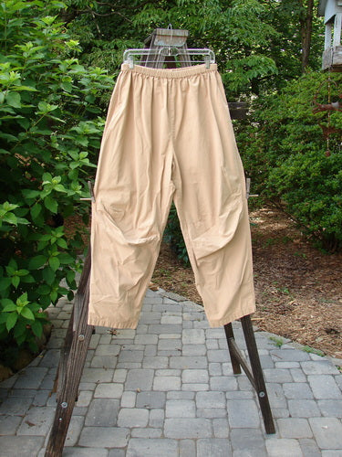 2000 Parachute Trekker Pant Unpainted Carmel Size 2: A pair of pants on a clothes rack, made from medium weight cotton parachute fabric. Features include additional knee fabric, slightly tapering lowers, and a full elastic waistline.
