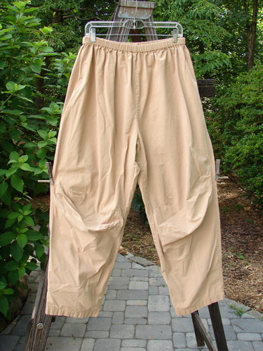 2000 Parachute Trekker Pant Unpainted Carmel Size 2: A pair of tan pants on a rack, made from a medium weight cotton parachute. Features include a full elastic waistline and additional knee fabric.
