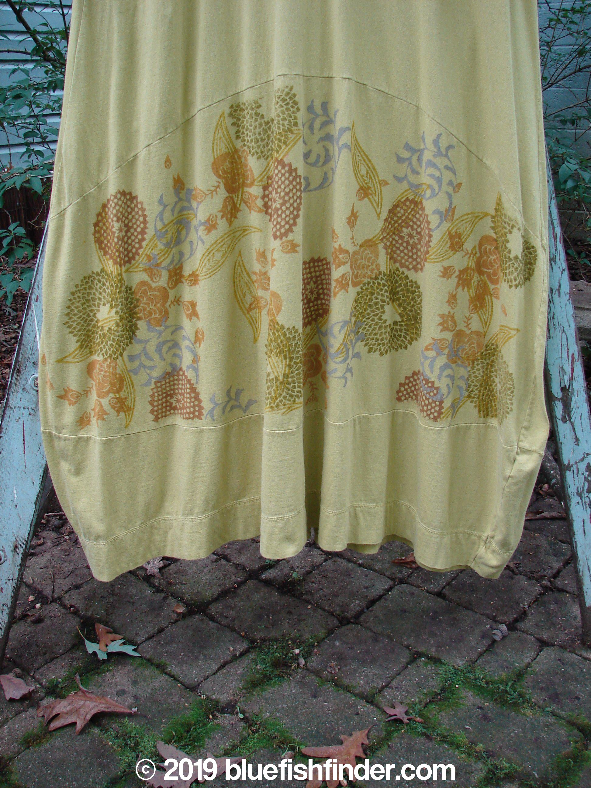 Image alt text: Barclay Gather Sectional Banded Petal Dress - a yellow dress with a floral design, featuring a V-shaped neckline, banded lower short sleeves, and a sweeping A-line shape. Perfect for a whimsical garden theme.