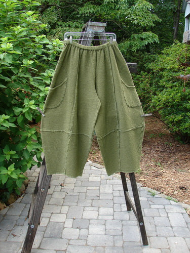 Barclay Crepe Sectional Pocket 4 Square Pant Unpainted Olive Size 1: A pair of green pants with unique bottom cut, generous hip pockets, and textured fabric.