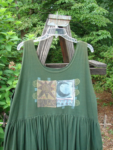1992 Peplum Dress Sun Moon Star Evergreen OSFA on a swinger, showcasing oversized vintage buttons, gathered peplum, and silk ribbon accents, highlighting its vintage charm and unique design details.