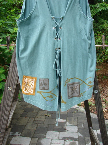 1993 Cha Cha Jumper Grey Green OSFA: A blue shirt with laces on a wooden ladder. A design on the shirt features branch and swirl patterns.
