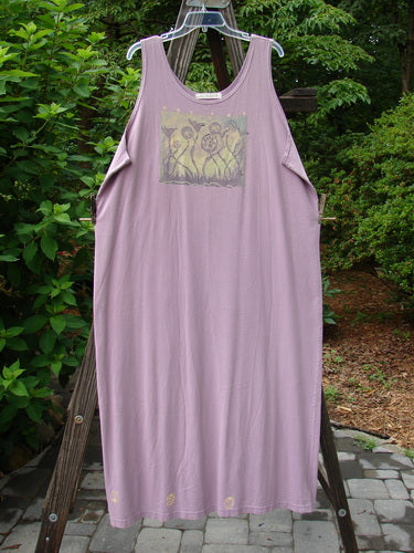 1997 River Journey Dress in Jasmine, Size 2: A purple dress on a wooden rack. Scoop rounded neckline, slim shape, deeper arm openings. Features growth theme paint and Blue Fish Patch.