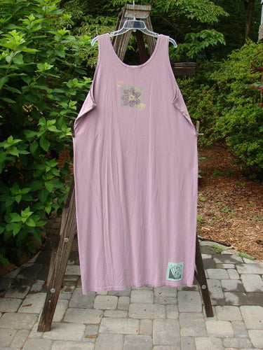 1997 River Journey Dress in Jasmine, Size 2: A purple dress with a growth theme paint design, hanging on a clothesline.