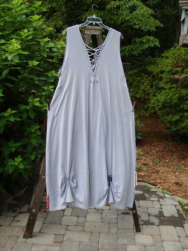 1997 Salt Water Taffy Jumper Rain Size 2: A dress on a clothesline with lace details, buttons, and tie accents.