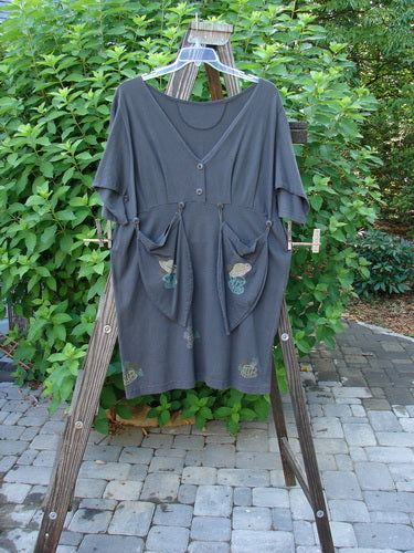 1994 Muse Dress Celestial Planet Blue Coal Size 1: A grey dress on a wooden rack with tear drop pockets and unique buttons.