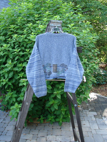 1994 Crop Cardigan Sweater Leaf Pod Haiku Blue OSFA: A blue sweater with leaf and pod motifs. Stoneware buttons, contrasting knits, and cozy longer sleeves.