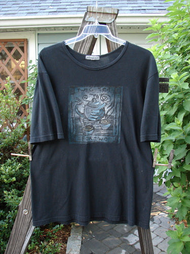 A black short-sleeved tee with a tea-themed paint design, organic cotton fabric, and Blue Fish signature stamp. Size 0.