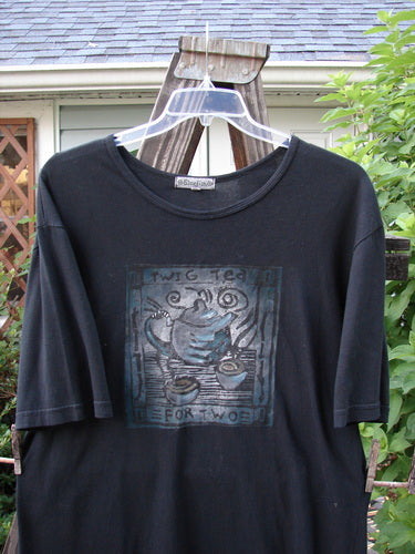 A black short-sleeved tee with a tea for two theme paint design. Made from organic cotton. Perfect condition. Size 0.