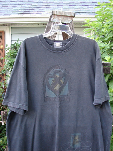 2000 Short Sleeved Tee Celtic Knot Black Size 2: A black t-shirt on a swinger, featuring a Celtic knot paint design on the sleeve.