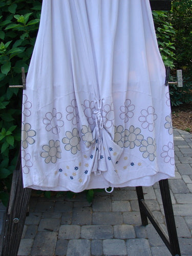 Image alt text: Barclay Spring Shade Skirt Circle Center, pale pink, featuring a white sheet with flowers, a close-up of a person's leg, and a metal post. Organic cotton, elastic waistband, varying hemline, rippie cord, loops for adjustments, sectional panels. Size 2.