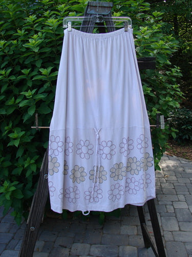 Barclay Spring Shade Skirt on a rack, featuring a floral pattern. Made from organic cotton, with a full elastic waistband and creative adjustments.