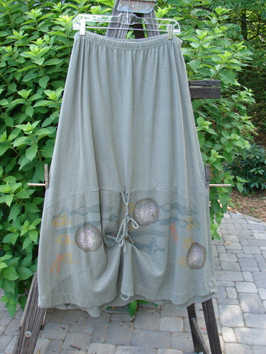 2000 Cotton Hemp Shade Skirt Biology Loden Size 2: A pair of pants on a clothes rack, a long grey skirt with a design on it, and a close-up of a curtain.