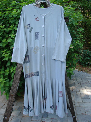 1994 Column Dress Heart Solstice Blue Size 1: A long grey robe with patches on it, on a wooden ladder.