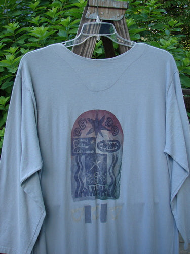 1994 Column Dress Heart Solstice Blue Size 1: A shirt with a picture on it, featuring a close-up of a bottle and a pair of glasses on a wooden stand.