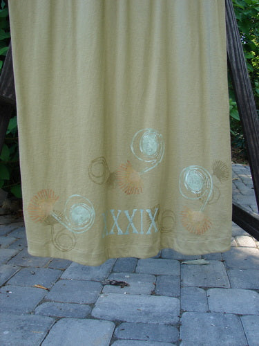 1998 Botanicals Calla Dress Puff Flower Seed Size 2: A tan towel on a brick surface, beige towel with a white design, stone surface with a curtain, and a number on a sign.
