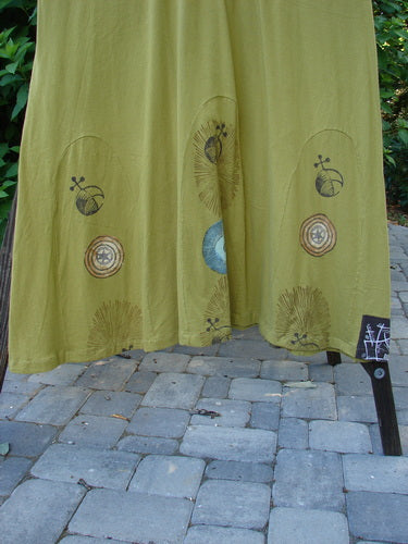 1998 Mystic Dress Celestial Terra Vert Size 2: A green cloth with abstract pinwheel designs, 3/4 length sleeves, and a super bubble hemline tied with a rope cord.