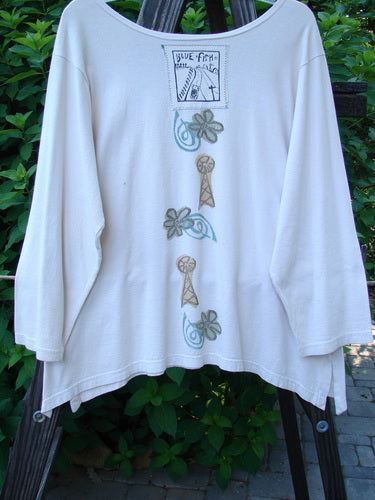 1993 Resort Blueline Top: White shirt with a design on it. Features wider boatneck neckline, drop shoulders, and three-quarter sleeves. Varying hemline with dramatic vented dippy side and tiny sweet vents. Vintage road less traveled theme with Blue Fish signature patch. Bust 40, waist 42, hips 46, sweep 52, front and back length 25, sides 28 inches.