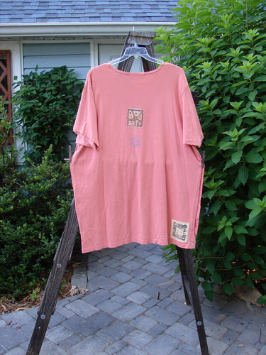1997 Mauritius Top Fern Fish Tangerine OSFA: A pink shirt with a design on it, featuring clear and textured floral buttons, tall side vents, and a wider longer square cut. Perfect for summer, this top is made from mid-weight organic cotton.