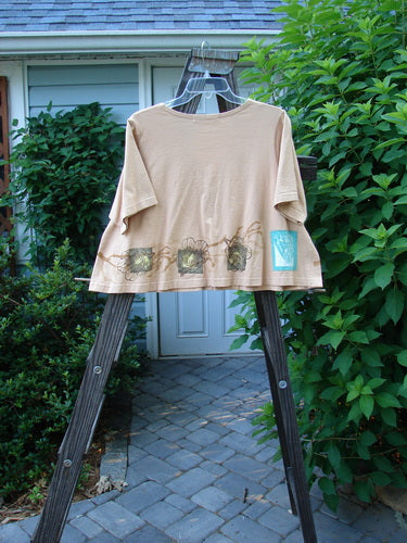 1997 Cove Jacket Sea Life Driftwood Size 1: A shirt on a rack, tan color, flared A-line shape, V neckline, swing style, fish patch, rounded pockets.