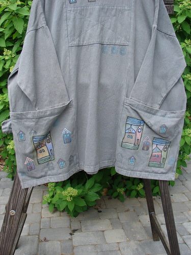 Image alt text: "Barclay Patched Canvas Urban Tunic Top - a grey shirt with drawings, featuring a split front rolled neckline, oversized pockets, and village theme paint. Size 2."