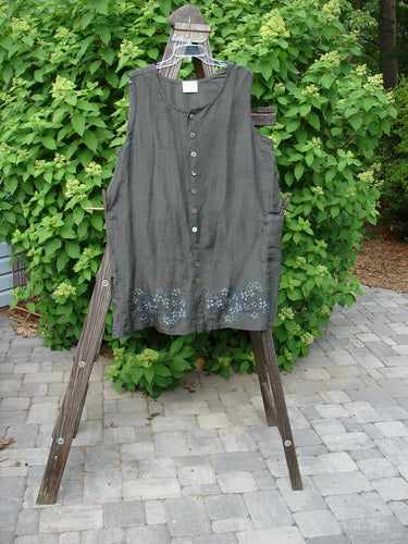 2000 Hemp Silk Sleeveless Vest Daisy Domino Size 2: A grey dress on a wooden stand, featuring a dipped rounded neckline, seamless bodice, and vented sides.