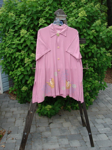 1999 Tarragon Top Tulip Daisy Raspberry Size 2: A pink shirt on a rack with a flower design, deep vented sides, and a pleated and gathered back.