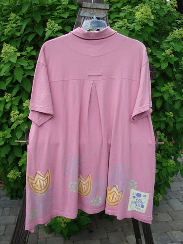 1999 Tarragon Top Tulip Daisy Raspberry Size 2: A pink shirt with a pattern on it, featuring a deep vented sides, a pleated and gathered back, and a varying hemline.