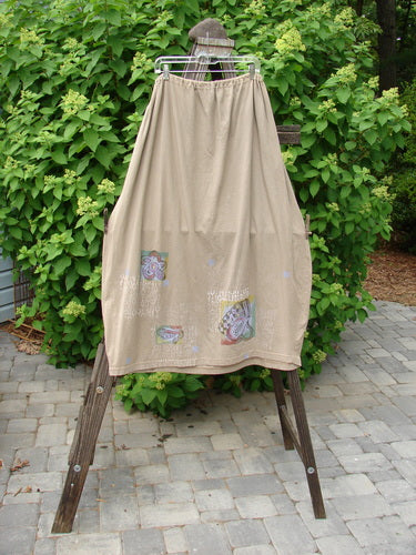 Image alt text: Barclay Big Pocket Skirt on clothes rack with ironing board and towel nearby. Drawstring waist, bell-shaped bottom, giant exterior pocket, deep side pockets. Waist 26-56, Hips 64, Length 40 inches.