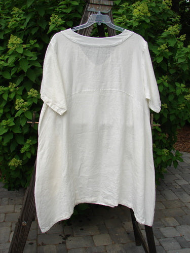 A white Barclay Linen Sailor Dress on a clothes rack, featuring a batiste adorned neckline, sway lower hemline, and drop front pockets. Size 2, unpainted.
