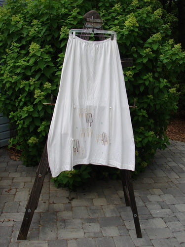 2000 Side Pocket Skirt Summer Treat White Size 2: A white skirt with a drawing on it, featuring a full elastic waistline, elastic-edged side pocket, and special loops for accents or extra drape. Sway with flare in this sectional figure 8-ish skirt with a super summer theme paint. Waist: 28-52, Hips: 52, Length: 39-42, Hem Circumference: 42 inches.