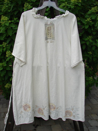 Barclay Linen Duet Sunrise Dress, a white robe on a clothes line with a floral design. Clothing, vestment.