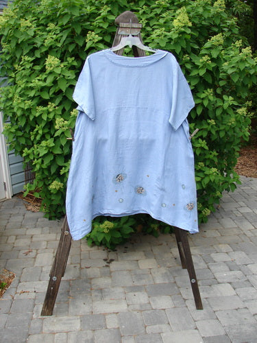 A Barclay Linen Sailor Dress in Celestial Blue Sky, size 2, on a clothes rack. Features include a batiste adorned neckline, swaying lower hemline, and empire waist seam.