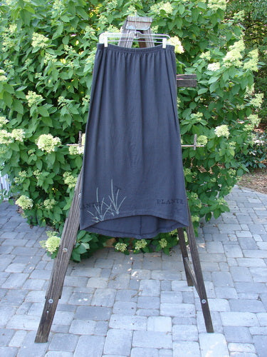 1998 Botanicals Corolla Skirt in Raven, Size 2. A slenderizing skirt made from organic cotton. Full elastic waistband, upward scooped front hemline. Pocketless design. Waist: 28-50, Hips: 50, Front Length: 34, Back Length: 40.