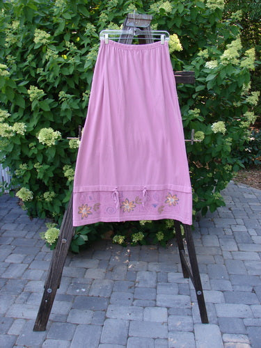 1999 Basket Skirt with Continuous Daisy theme, Raspberry color. Medium weight organic cotton. Elastic waistband, deep side pockets, A-line flair, specialized bottom with Raspberry Rippies. Size 0.