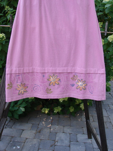 1999 Basket Skirt: A pink skirt with flowers on it. Features an elastic waistband, deep side pockets, and a specialized bottom with raspberry accents. Size 0.