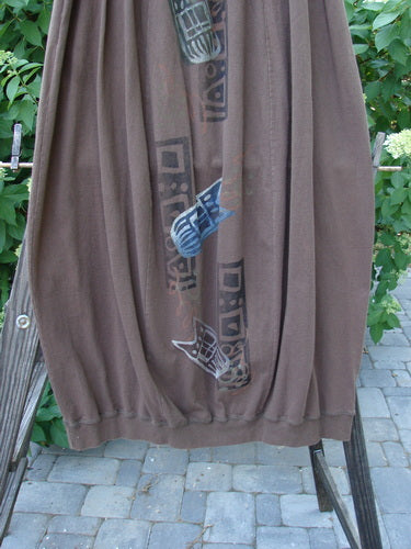 Image alt text: 1996 Thermal Whimsical Skirt Tribal Molasses Size 2 - Brown pants with a blue tribal design, gathered ribbed hemline, and deep side pockets.