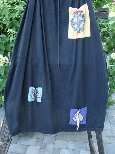 1996 Destination Skirt Blue Fish Logo Path Black Size 2: A blue skirt with patches on it, featuring a drawstring waistline, painted pockets, and a widening lower bell shape.