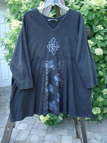 1997 Jester's Dress Moon Celtic Obsidian Size 2: A black dress with a design on it, featuring a V cross-stitched neckline, wide swinging A-line shape, and empire waist seam. Includes draw cords, a signature Blue Fish patch, and continuous Celtic moon theme paint.