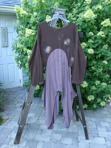 A long sleeved shirt on a wooden rack, featuring the Barclay NWT Calligrapher's Jacket in Lilac Mocha. Perfect condition, made from organic cotton. Dramatic and unique shape with long dippy sides and open hips. Can be worn as pictured or knotted, open or buttoned. Deep V-shaped neckline and specialized four-button front. Painted in a striking alternating two-tone contrast. Bust 56, waist 60, hips 70, open rear length 35, and side lengths 56 inches.