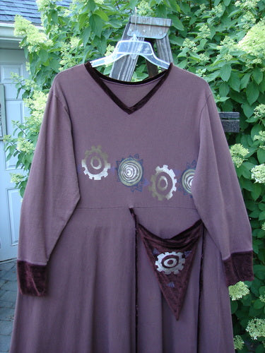 A 1996 Velvet Ornamental Pocket Dress Spirograph Spicewood Size 1. A purple dress with a design on it. Velvet accents on the neck, hem, and sleeve trim. A tie-on, tie-off long velvet rippie cord. A dramatic painted hand purse. A huge sweeping A-line shape. Abundant spirograph theme paint. Perfect condition with minor repairs. Bust 48, waist 48, hips 46, hem circumference 100, length 55 inches.