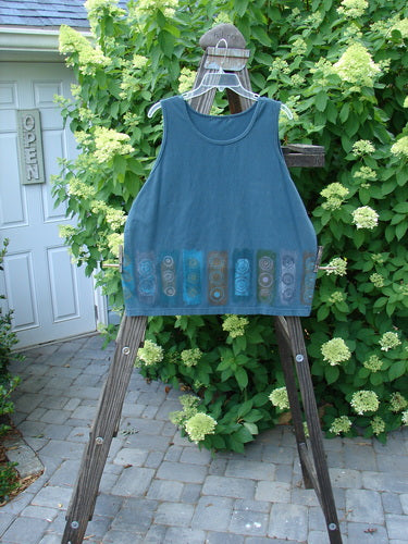 A Barclay Cotton Lycra Summer Tank in Puddle, size 1, on a wooden stand. Flattened neckline, tapered shape, medium weight. Bust 50, waist 48, hips 48, length 25.