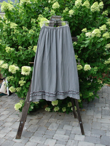 Barclay Rib Silk Double Flutter A Line Skirt Unpainted Silver Gray Size 2: A skirt on a rack, featuring a full elastic waistline, double ruffle flutter, and a silken vertical texture. Perfect condition with light fade marks.