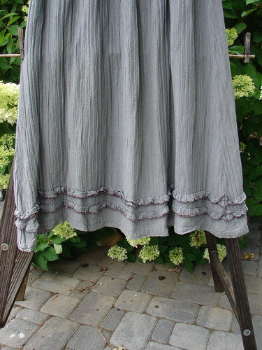 Barclay Rib Silk Double Flutter A Line Skirt Unpainted Silver Gray Size 2: A skirt on a rack, featuring a full elastic waistline and a super swingy flirty bottom with a continuous double ruffle flutter. Made from lovely flowing rib silk, this skirt is fancy and falls with a larger sweep.