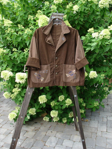1997 Mason's Jacket on wooden stand, featuring folded neckline, painted pockets, cuffed cord sleeves, and metal buttons. Structurally themed paint with sectional back.