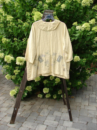 1999 Linen Antique Top Garden Plantain Size 1: A coat and white shirt on a rack. Close-up of the shirt's wooden post.