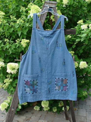 Image alt text: Barclay Canvas Urban Pocket Apron Jumper with Mosaic Chair design on a wooden easel, made from Heavy Weight Hemp Twill. Features tear button accents, fixed shoulder straps, and two drop front pockets. Size 1.